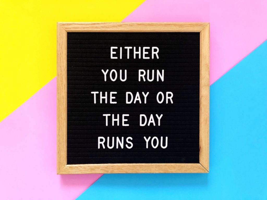 A sign that says "either you run the day or the day runs your"